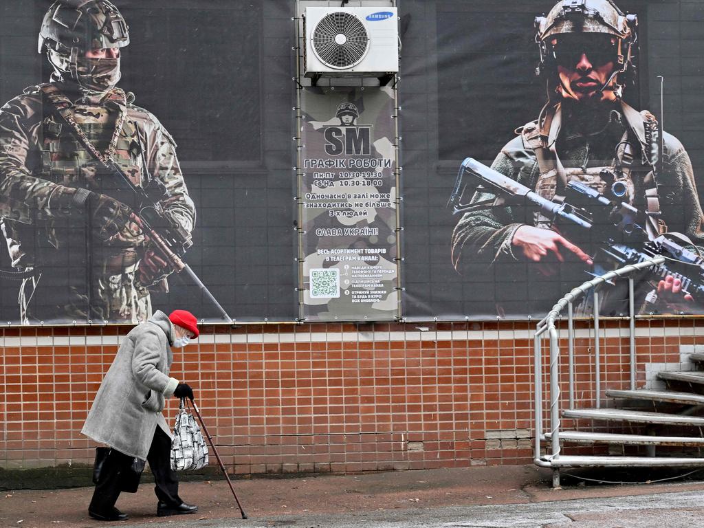 An elderly woman walks past placards that hang from shop windows depicting Ukrainian servicemen on the Orthodox Christmas Eve. Picture: AFP