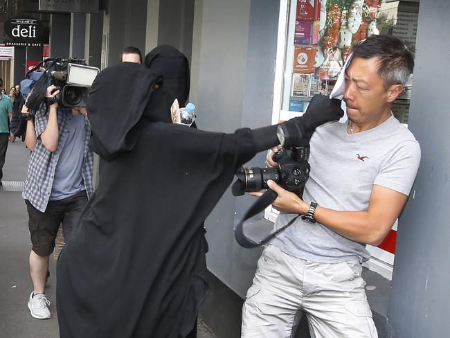 A woman dressed in a niqab lashing out at a photographer. Picture: David Caird