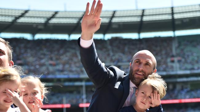 Chris Judd waves to the crowd at the 2015 AFL Grand Final in a lap of honour with other retiring player. Picture: AAP