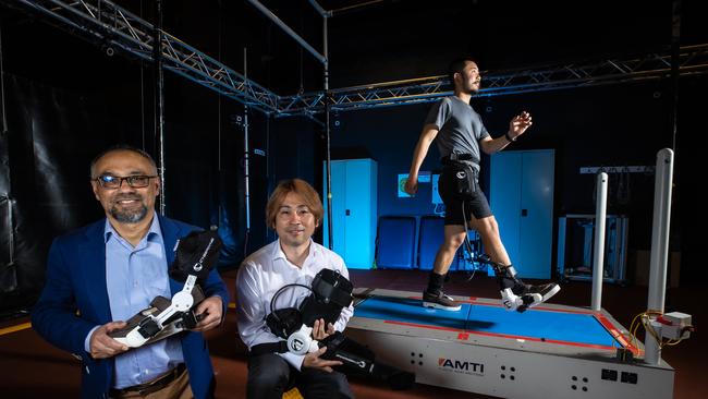 Victorian researchers Professor Rezaul Begg and Dr Hanatsu Nagano, pictured with Kai Wang, hope an exoskeleton can help people in wheelchairs walk again. Picture: Jason Edwards