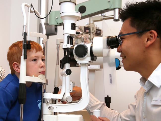 Kevin Paisley optometrist Jason Loh with young patient Oli Pryke and mum Lauren Middleton. Picture: Alison Wynd