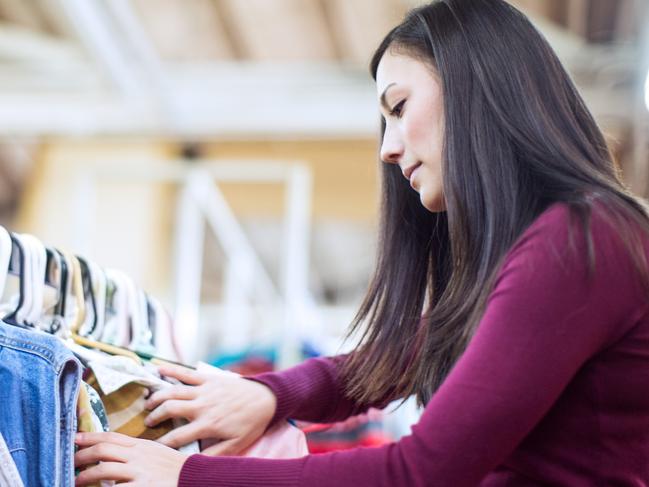 A beautiful young adult woman in her early 20's shops looking at a second hand clothes. Picture: iStock.