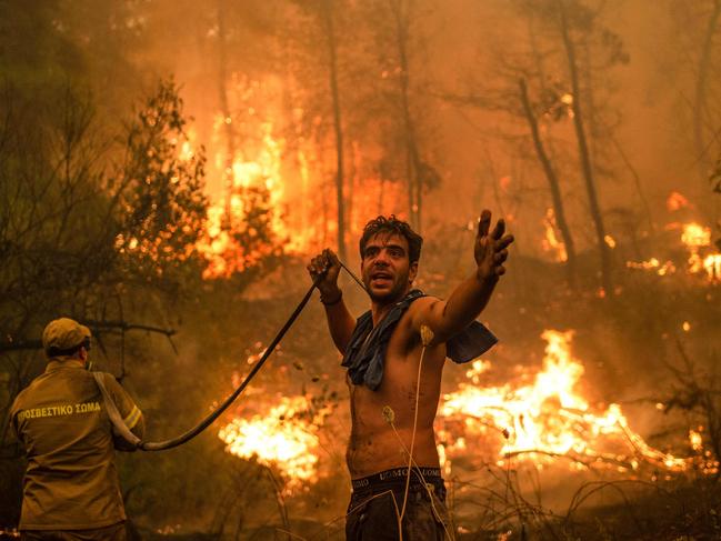 A local resident gestures as he holds an empty water hose during an attempt to extinguish forest fires approaching the village of Pefki on Evia (Euboea) island, Greece's second largest island, on August 8, 2021. Picture: AFP