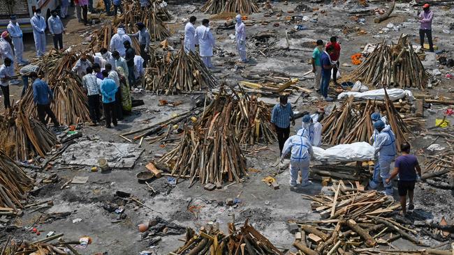 Family members prepare funeral pyres at a makeshift crematorium in New Delhi