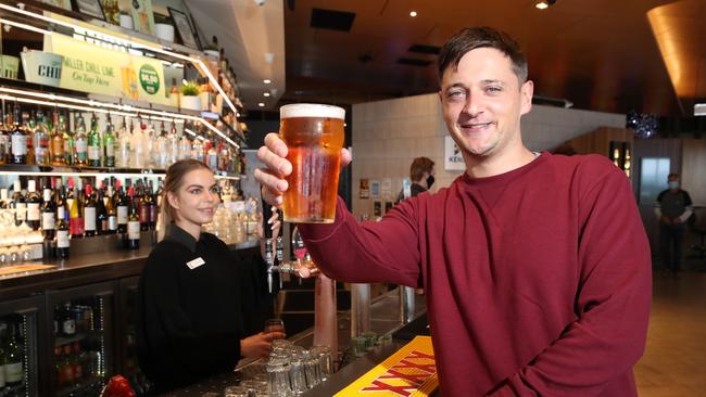 Punter Daniel Kenney enjoys a beer from Kurrawa SLSC bartender Connor Thorn. Picture: Glenn Hampson