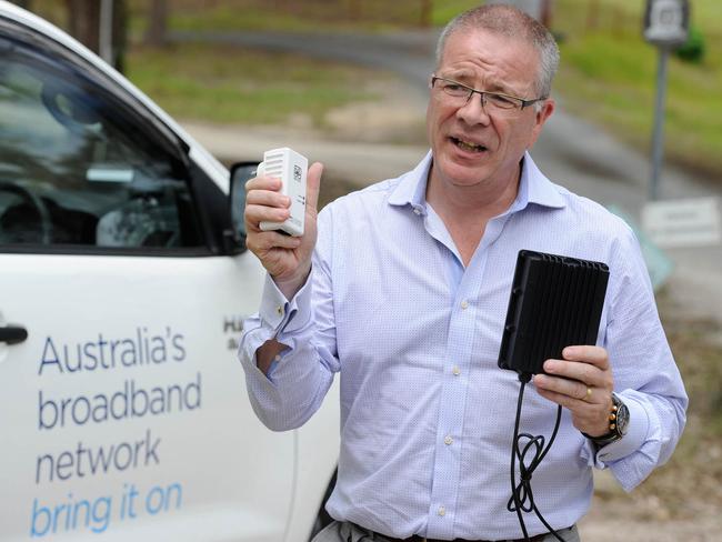 NBN principal technology officer, Tony Cross, with a DPU and a plug-in power pack used in the home of the customer.