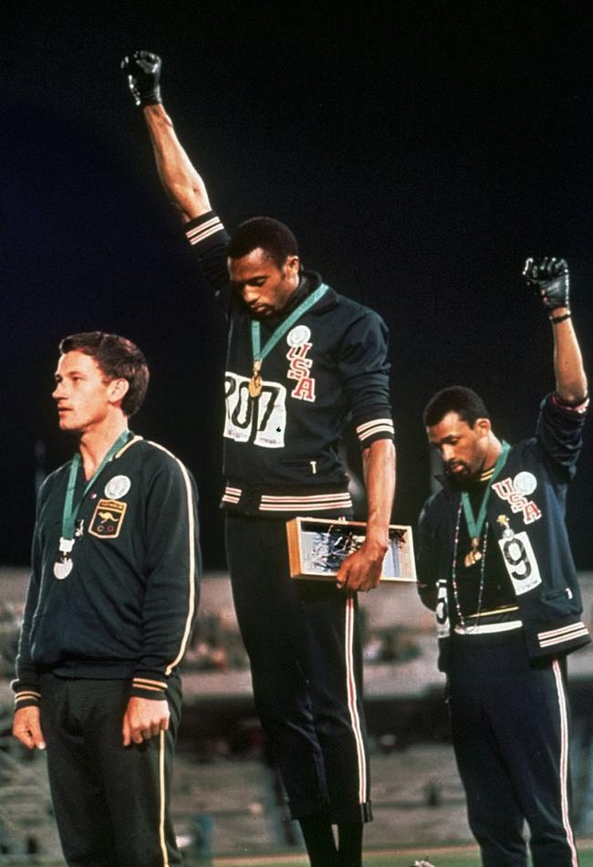 Olympic silver medallist, Australian Peter Norman (left), wearing an OPHR (Olympic Project for Human Rights) badge, stands as US athletes Tommie Smith (centre) and John Carlos (right), raise their black-gloved fists in protest at the Mexico City Olympic Games on October 16, 1968.