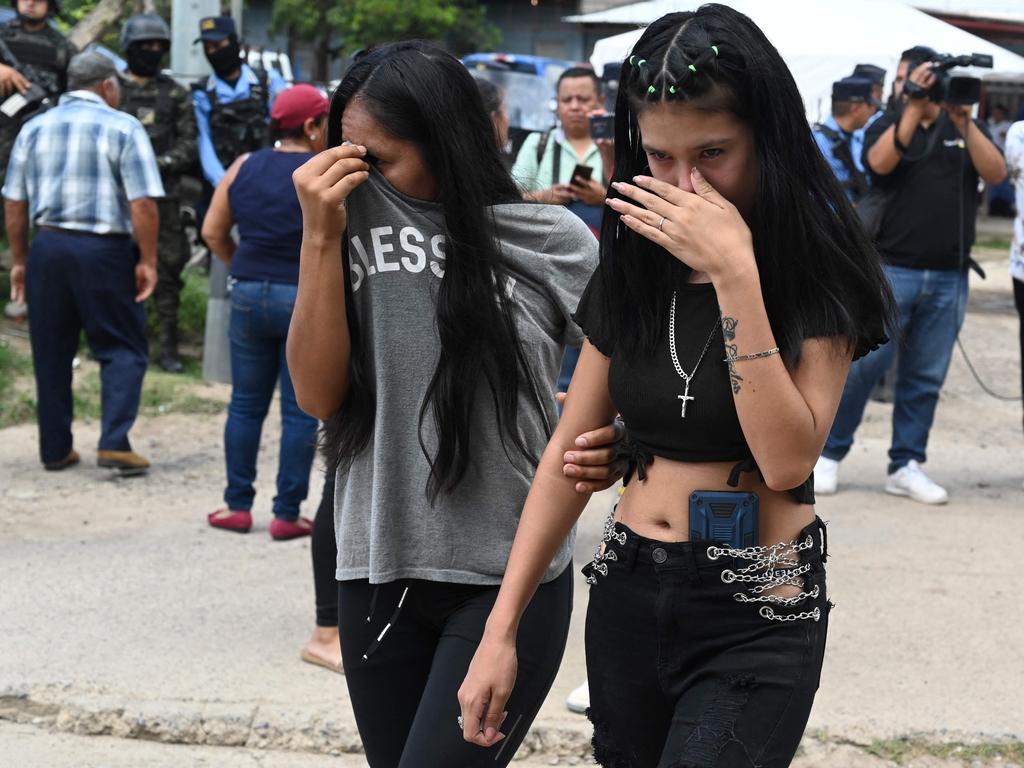 Women crying outside the facility. (Photo by Orlando SIERRA / AFP)