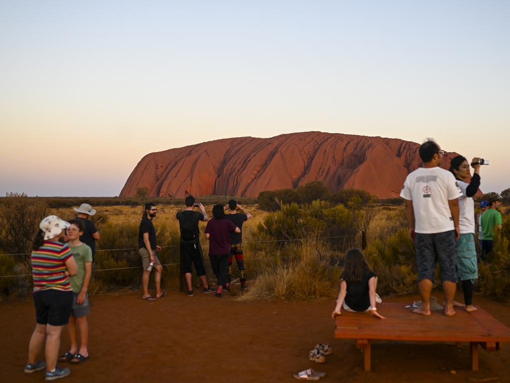 Tourists observe Uluru, also known as Ayers Rock during sunset at Uluru-Kata Tjuta National Park in the Northern Territory, Thursday, October 10. Picture: AAP Image/Lukas Coch