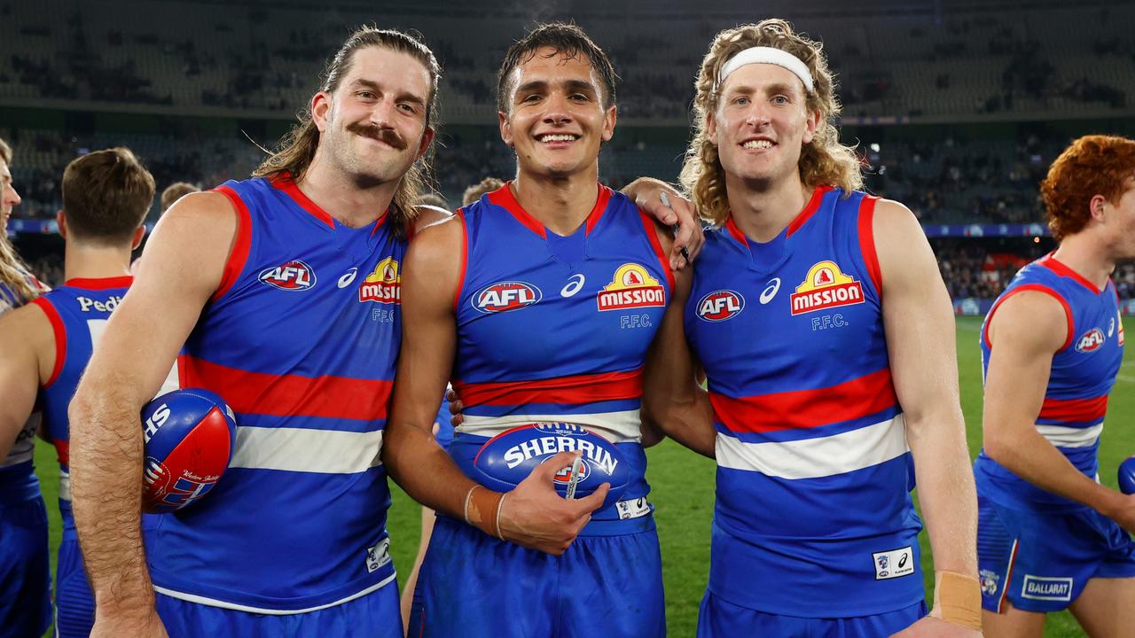 MELBOURNE, AUSTRALIA - JULY 23: (L-R) Josh Bruce, Jamarra Ugle-Hagan and Aaron Naughton of the Bulldogs celebrate during the 2022 AFL Round 19 match between the Western Bulldogs and the Melbourne Demons at Marvel Stadium on July 23, 2022 in Melbourne, Australia. (Photo by Michael Willson/AFL Photos via Getty Images)