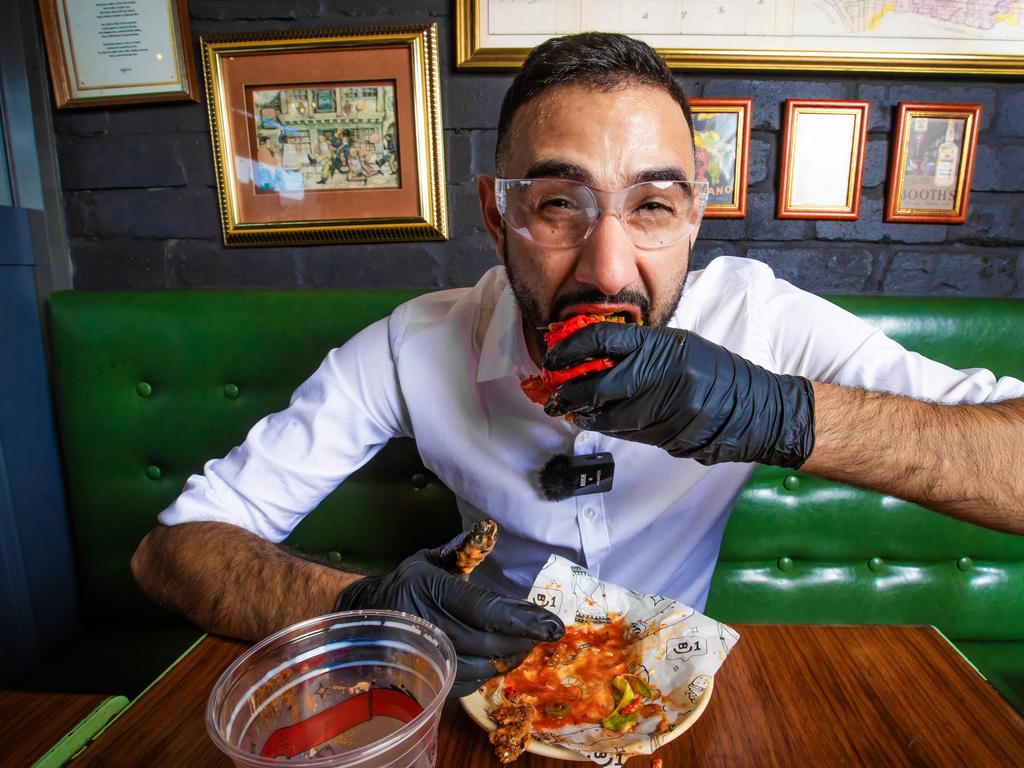 Courier Mail journalist Mohammad Alfares tries out the Scorpion Deathwish at Burger Urge. Picture: Nigel Hallett