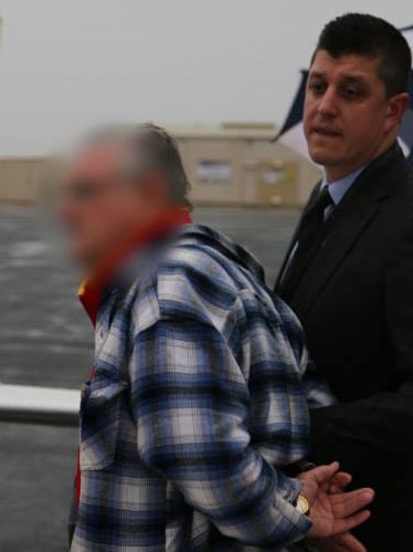 John Charles White is taken into custody — the pixelated image was supplied by NSW authorities.