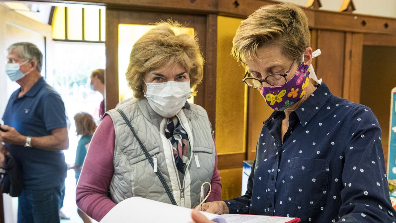 Regular St Patrick's Cathedral parishioner Beverley Price (left) is signed in by Ann Maree Ford for the Good Friday service after Easter church services were given the green light following the easing of COVID restrictions, Friday, April 2, 2021. Picture: Kevin Farmer