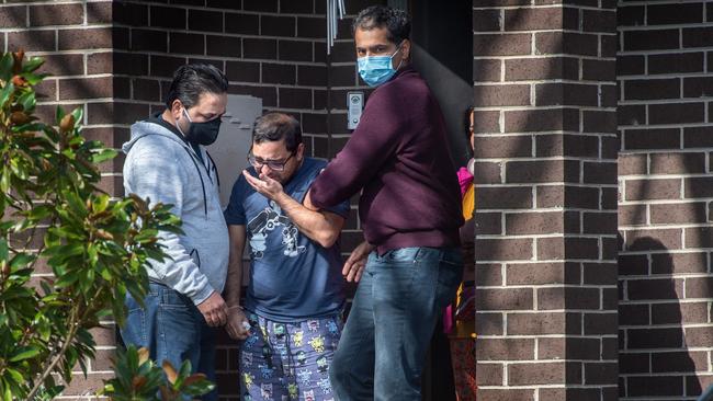 Ayan’s distraught dad (centre) is comforted at their Blackburn South home. Picture: Tony Gough