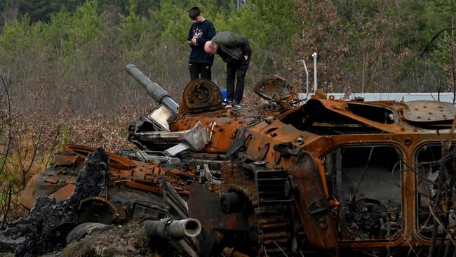 A father and his son examine destroyed Russian tanks and armoured personnel carriers in Dmytrivka village, Kyiv region. Picture: AFP.