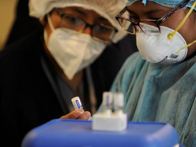 Health workers look at a vial of Russia's Sputnik V vaccine against COVID-19, at the Cotahuma Hospital in Bolivia. Picture: AFP