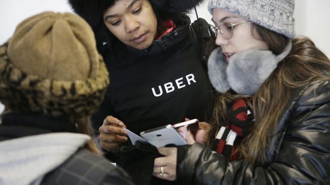 An Uber employee helps travellers at LaGuardia Airport in New York. Picture: Seth Wenig/AP