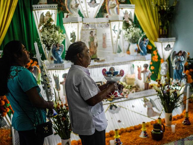 Maria Isabel Vargaz takes part in a ritual next to a Monumental Altar dedicated to her brother migrant Pablo Vargaz Mendoza 60, who died in New York of COVID-19. Picture: AFP