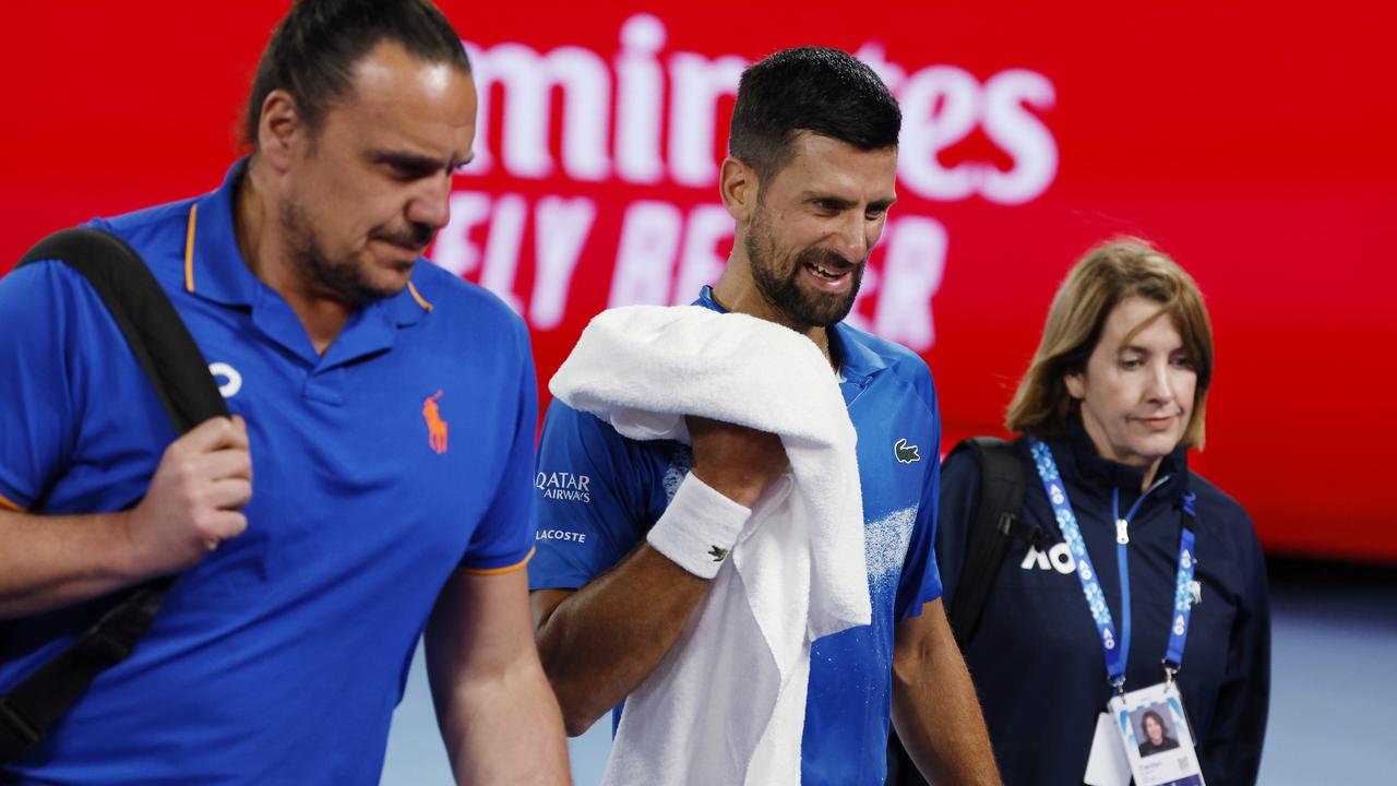 Novak Djokovic leaves the court with medicos for an injury time out after the first set. Picture: Michael Klein