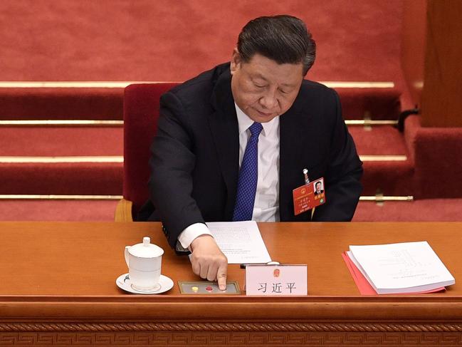 (FILES) This file photo taken on May 28, 2020 shows China's President Xi Jinping voting on a proposal to draft a security law on Hong Kong during the closing session of the National People's Congress at the Great Hall of the People in Beijing. - China passed a sweeping national security law for Hong Kong on June 30, 2020, a historic move that critics and many western governments fear will smother the finance hub's freedoms and hollow out its autonomy. (Photo by NICOLAS ASFOURI / AFP)