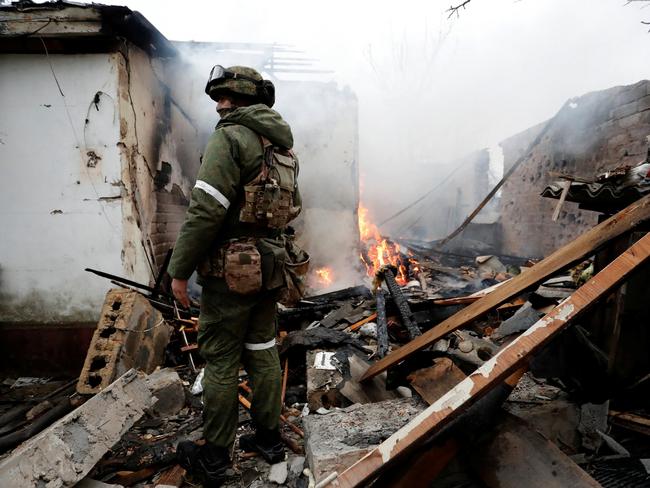 A serviceman of pro-Russian militia stands next to a house that caught fire after recent shelling, in the separatist-controlled city of Donetsk, Ukraine. Picture: REUTERS/Alexander Ermochenko