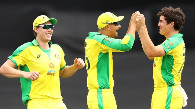 Sean Abbott of Australia celebrates with his team mates Cameron Green and Ashton Agar of Australia after taking the wicket of Shikhar Dhawan of India during game three of the One Day International series between Australia and India at Manuka Oval on December 02, 2020 in Canberra, Australia. (Photo by Mark Kolbe/Getty Images)