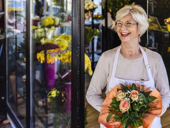 Senior Florist Small Business Flower Shop Owner standing while holding beautiful bouquet with roses; Senior employee generic