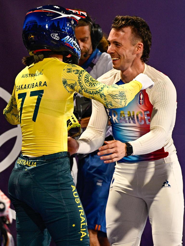 Saya is embraced by Romain. The couple collected a gold and bronze medal in the event. (Photo by JULIEN DE ROSA / AFP)