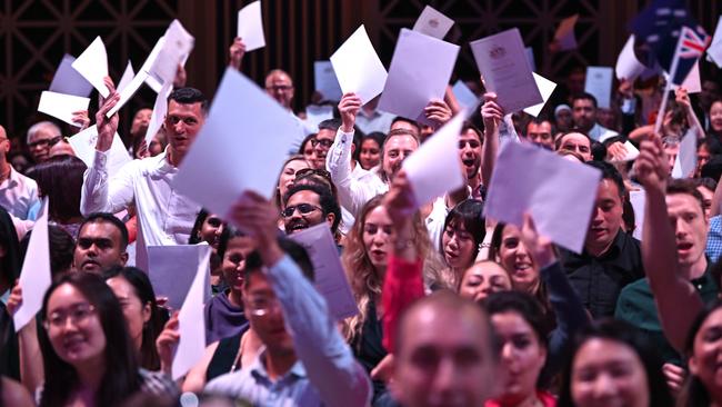 New citizens proudly wave their certificates at an Australia Day citizenship ceremony at the Brisbane Town Hall in 2024. Picture: Lyndon Mechielsen