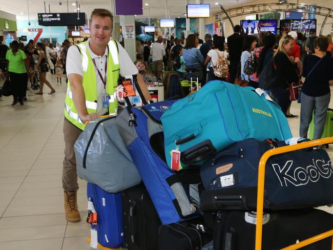 Queensland Airports Limited CEO Chris Mills loading luggage during one of the busiest days ever at Gold Coast Airport. Picture Glenn Hampson