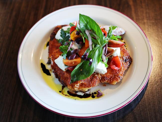 A caprese salad tops a juicy, perfectly crumbed chicken schnitzel. Picture: Rebecca Michael