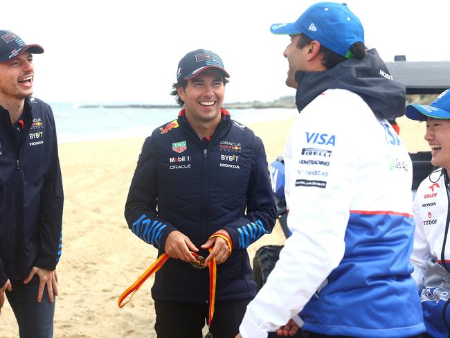 Red Bull’s Max Verstappen, Sergio Perez, Yuki Tsunoda and Daniel Ricciardo share a joke on a Melbourne beach. Picture: Getty