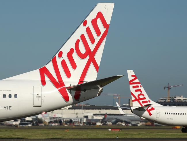 The Virgin Australia Holdings Ltd. logo is displayed on the tails of a Boeing Co. 737-800, left, and a Boeing Co. 737-8FE aircraft preparing to take off at Sydney Airport in Sydney, Australia, on Monday, Feb. 8, 2016. Virgin Australia is scheduled to announce half-year earnings on Feb. 11. Photographer: Brendon Thorne/Bloomberg