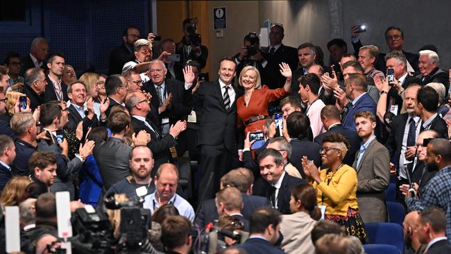 Truss and her husband Hugh O'Leary wave to applauding delegates as they leave after delivering her keynote address on the final day of the annual Conservative Party Conference in Birmingham, central England, on October 5.