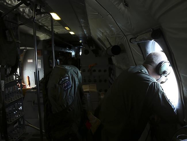 An observer looks out a window onboard a RNZAF P3 Orion during the search operations for missing Malaysia Airlines Flight MH370 in Southern Indian Ocean on April0 4, 2014. 