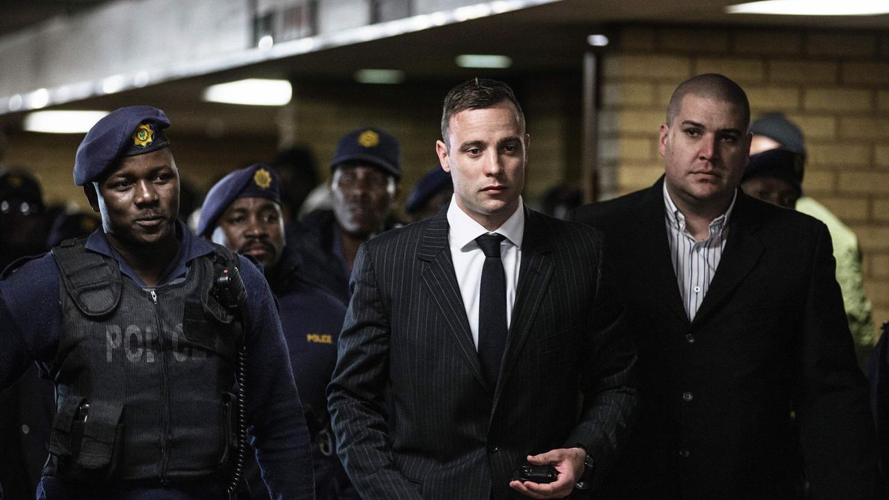 South African Paralympian Oscar Pistorius surrounded by policemen as he arrives at Pretoria High Court for a sentencing hearing in June, 2016. AFP PHOTO / GIANLUIGI GUERCIA.