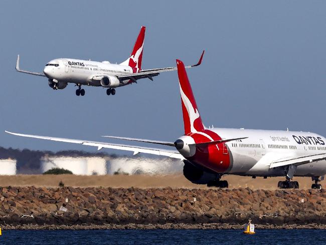 This photo taken on September 4, 2024 shows a Qantas Airways Boeing 737-800 plane coming in to land next to a Qantas Airways Boeing 787 Dreamliner aircraft preparing to take-off at Sydney International Airport. (Photo by DAVID GRAY / AFP)