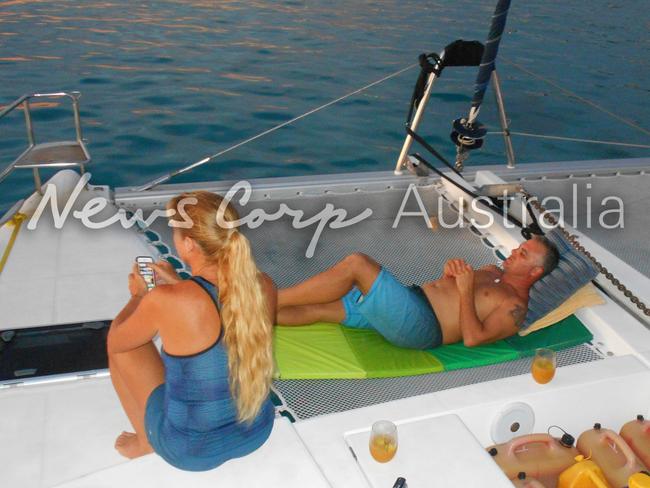 John and Yvette Nikolic on the bow of the yacht with drinks. Picture: Jeff Hassell.