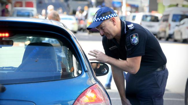 Acting Sargeant Paul Stanford talks to a motorist in Brisbane City. Picture: Jamie Hanson.