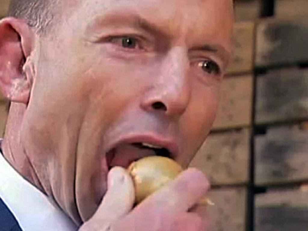 Tony Abbott eating an onion during a visit to Charlton Farm Produce at Moriarty.