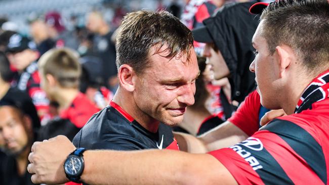 A crying Brendon Santalab is consoled by Wanderers fans after the 5-0 defeat by Sydney FC.
