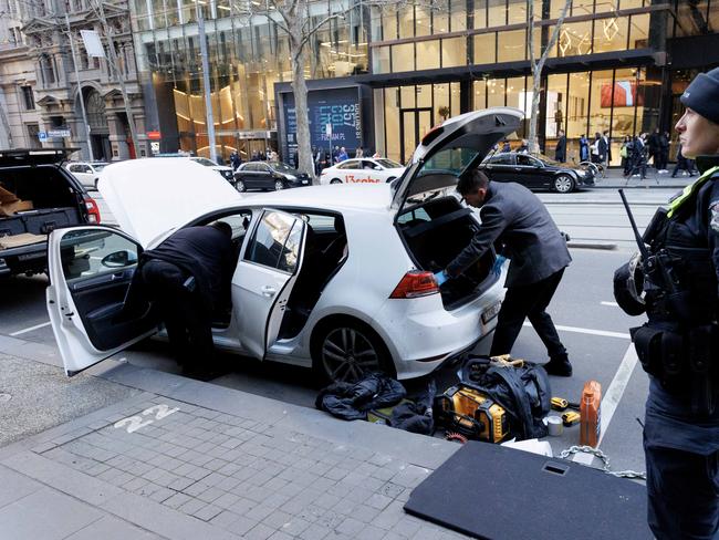 MELBOURNE, AUSTRALIA - NewsWire Photos - JUNE 19, 2024.  Police go through a white hatchback on Collins st after a major police incident with people reporting they were told to stay inside their office buildings.Picture: David Geraghty / NewsWire