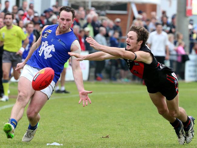 Scott Jansen of Hastings just gets his kick away on time. Picture: Mark Dadswell