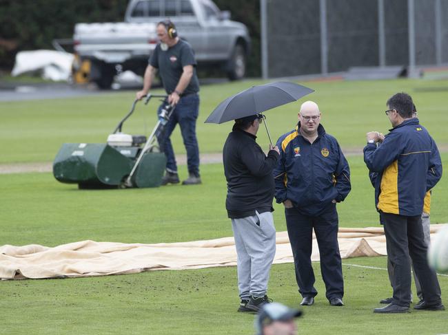 Groundsmen work to get the pitch ready for play. Picture: Chris Kidd