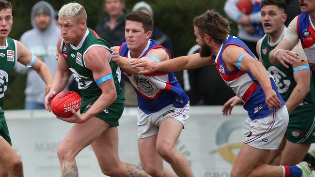 NFL: Greensborough’s Josh Caddy tries to escape Billy Hogan and Jesse Tardio of North Heidelberg. Picture: Hamish Blair