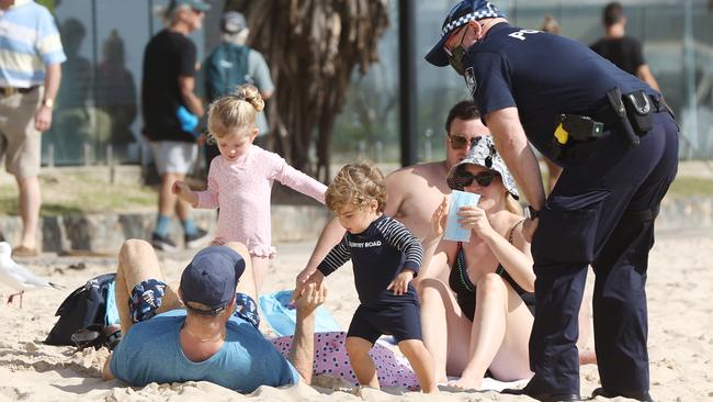 Police talk to beachgoers on Noosa Main Beach about adhering to Covid-19 restrictions during a snap lockdown. Picture Lachie Millard