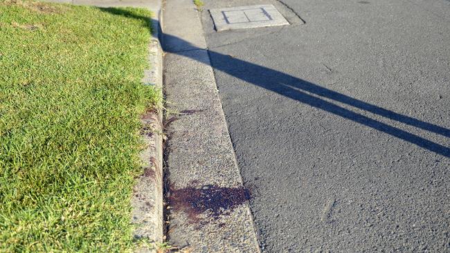 Bloodstains on the roadside outside the scene of a shooting outside A-Team mechanics. Photo Jeremy Piper