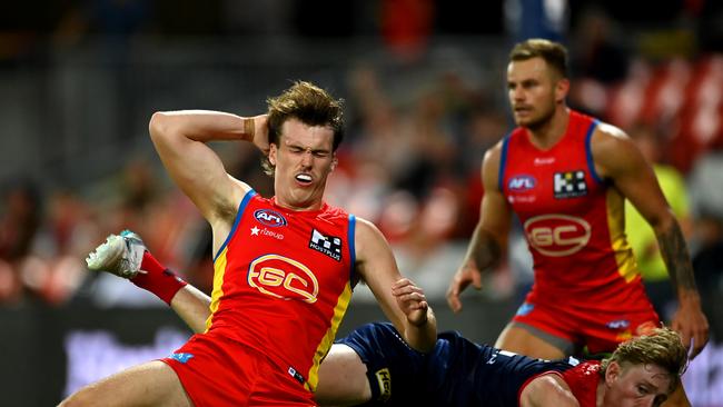 The Suns’ Charlie Ballard falls after being struck by the Demons’ Jacob van Rooyen. Picture: Albert Perez/AFL Photos via Getty Images