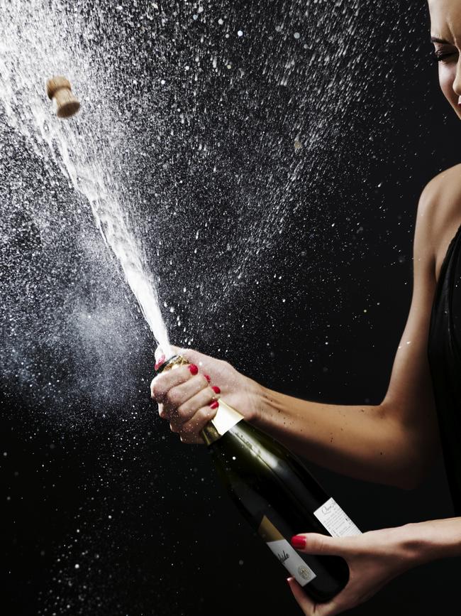 Girl shaking up bottle of champagne