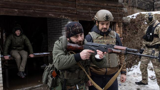 A member of the Georgian National Legion paramilitary volunteer unit (L) instructs a civilian on shooting techniques during a training course at a shooting range. Picture: Chris McGrath/Getty Images